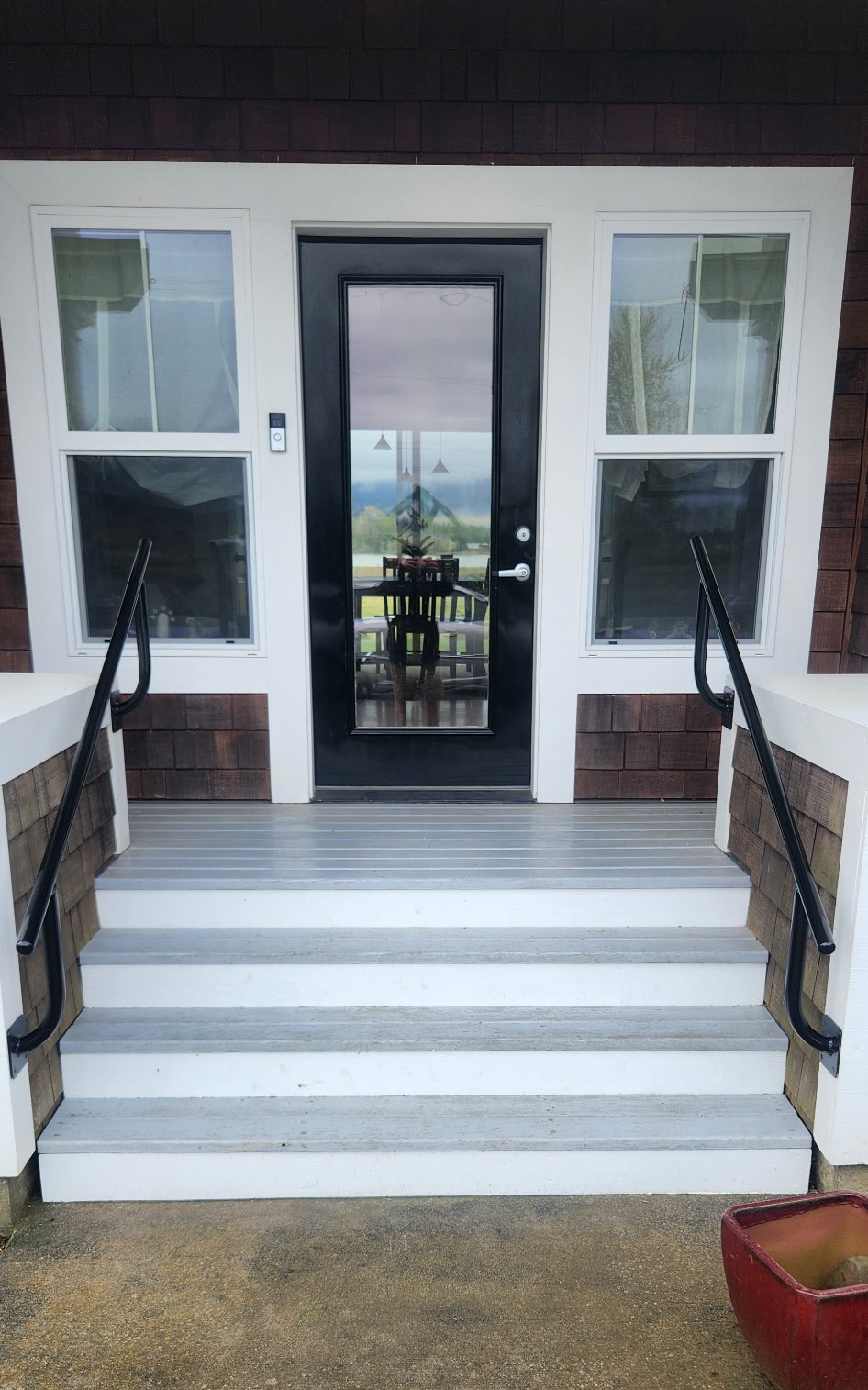 Black powder-coated steel handrails on a residential porch